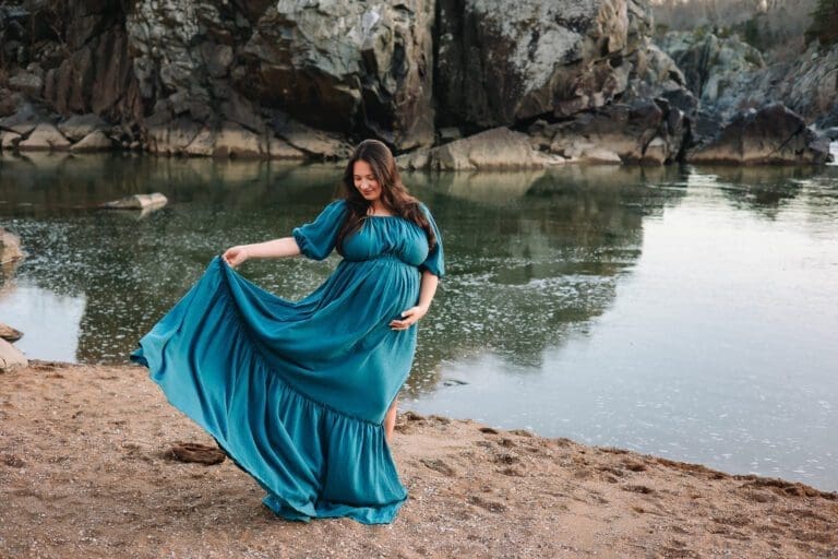 Expectant mom twirling her skirt on the beach at Great Falls Park.