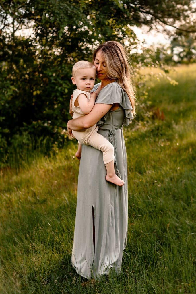 mom holds baby in field