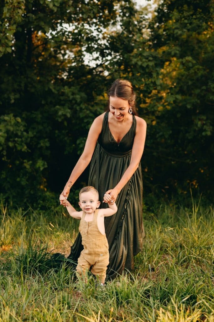 Banks Family Mom holds hands to walk with her baby during a sunset photo session in Central Maryland.