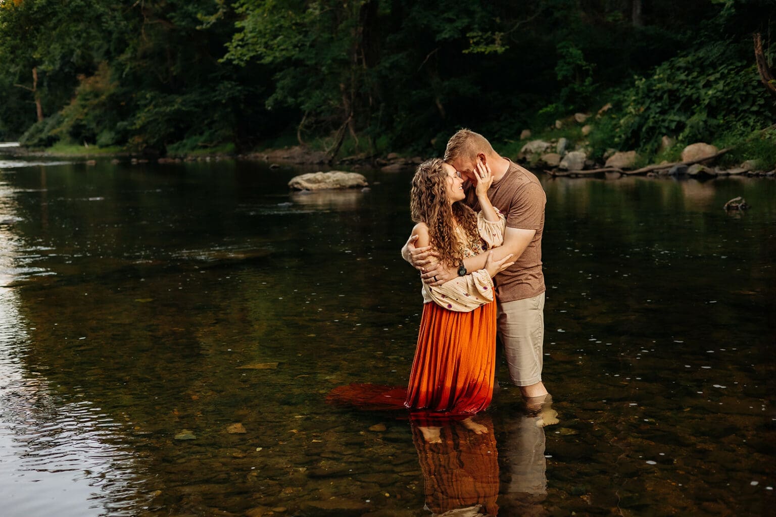 Romantic couple embracing in the river, reflecting a quiet moment of intimacy surrounded by nature, ideal for couples' lifestyle photography.