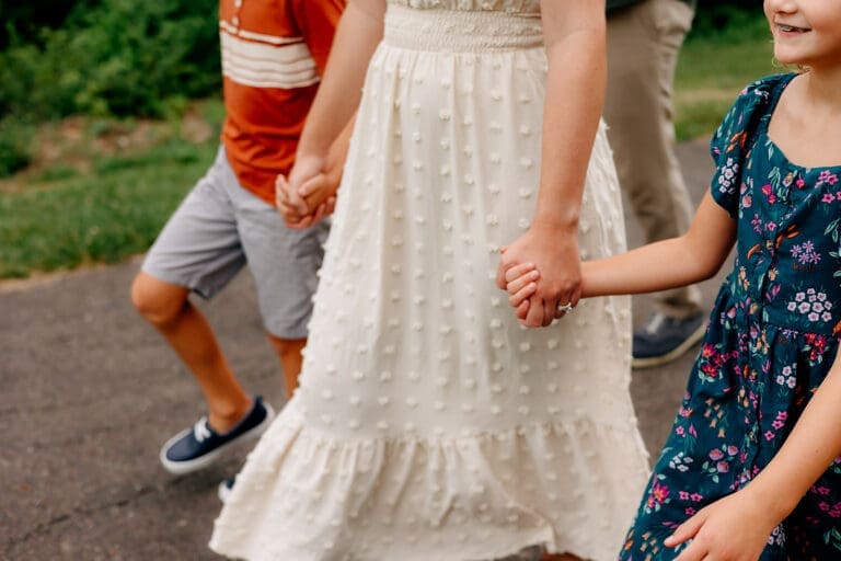 A close-up of the family walking, focusing on the children holding hands with the parents.