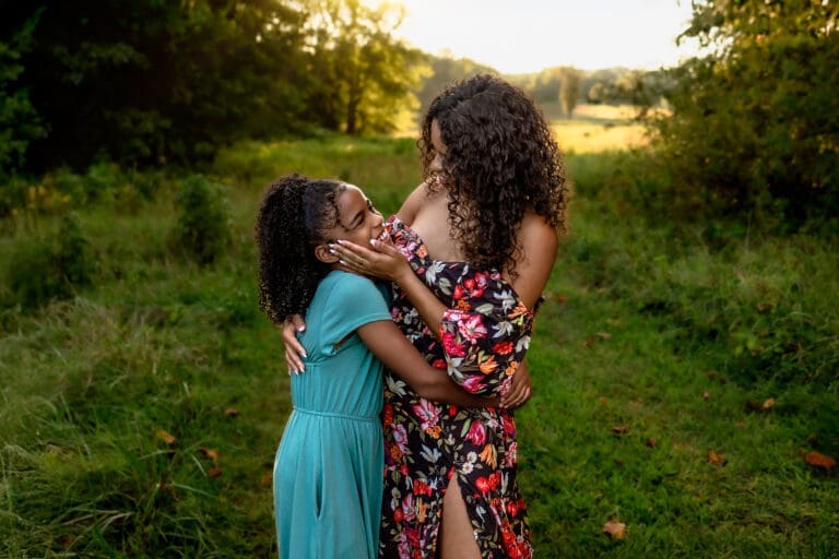 Joyful moment between mother and daughter hugging and smiling during a warm, candid Mothers Day family photo session in Maryland.
