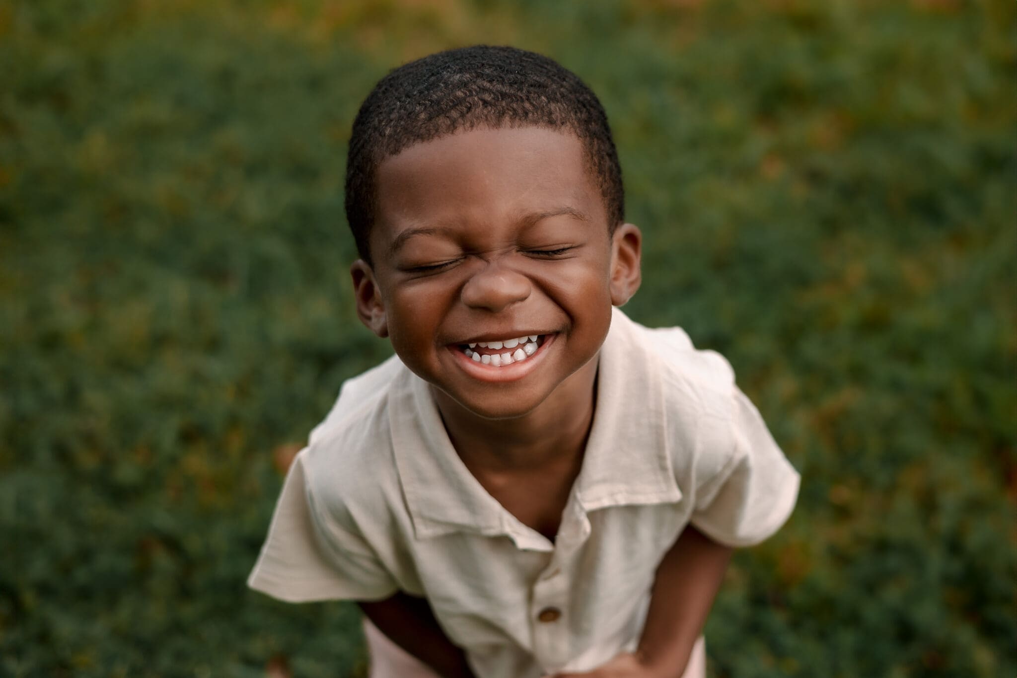 Little boy laughing close to the camera in natural light