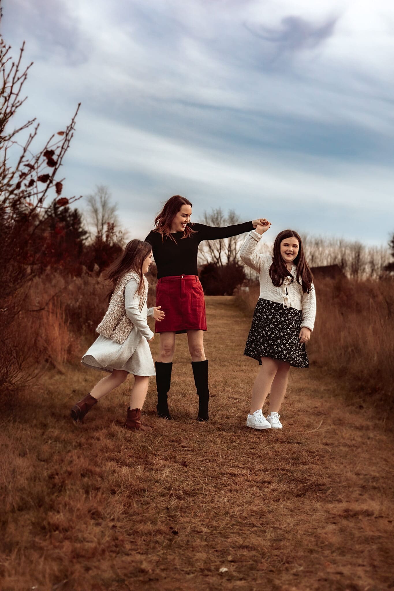 Mother walking hand-in-hand with her daughters during a candid outdoor family photography session in Bowie, Maryland.