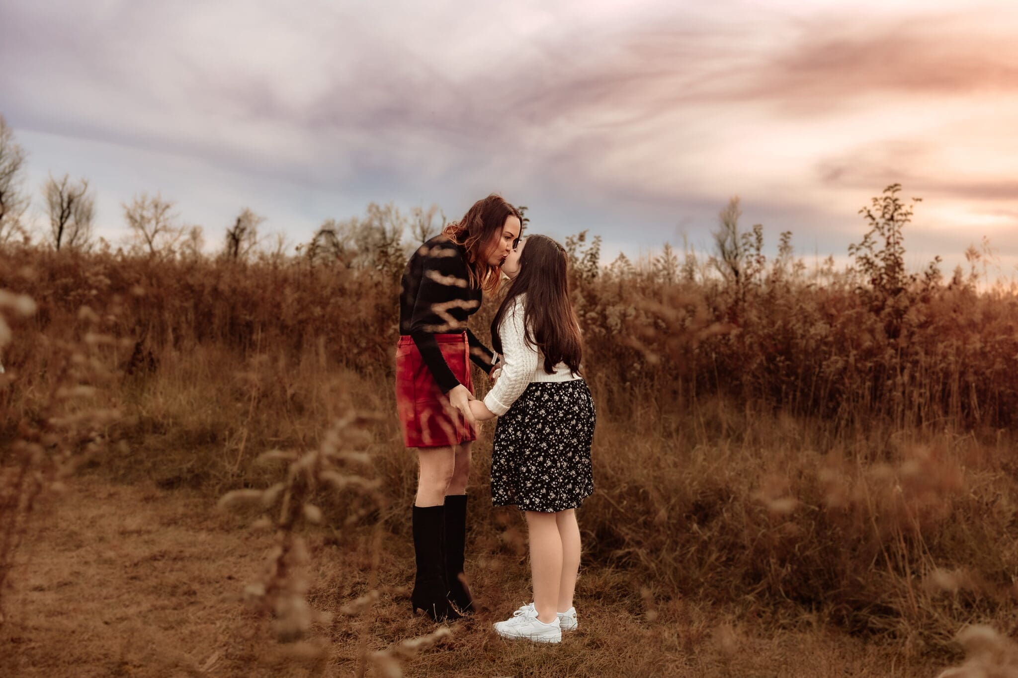 Mother kissing her daughter during golden hour outdoor family photos in Bowie, Maryland.